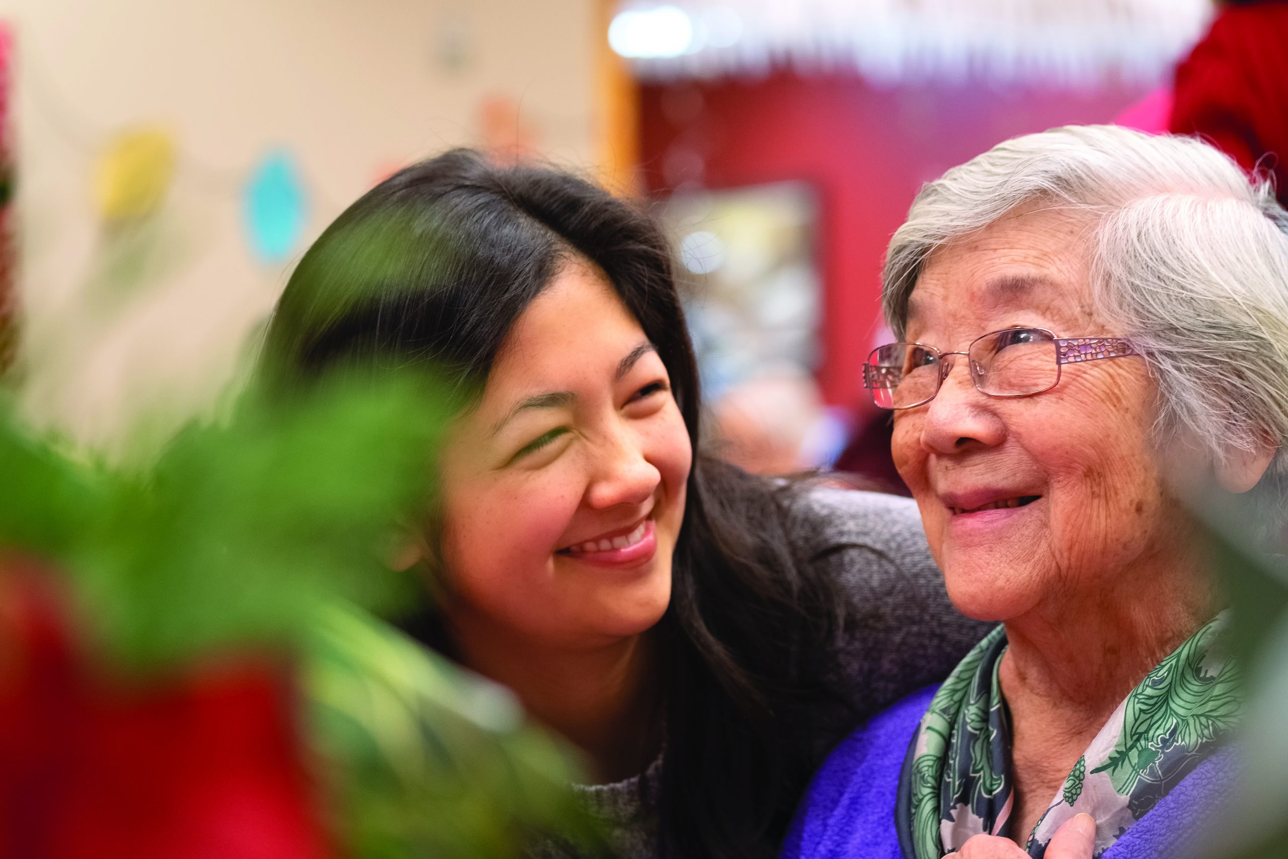 Asian Grandmother and Mixed-Ethnic Granddaughter Enjoying Christmas Celebration Together