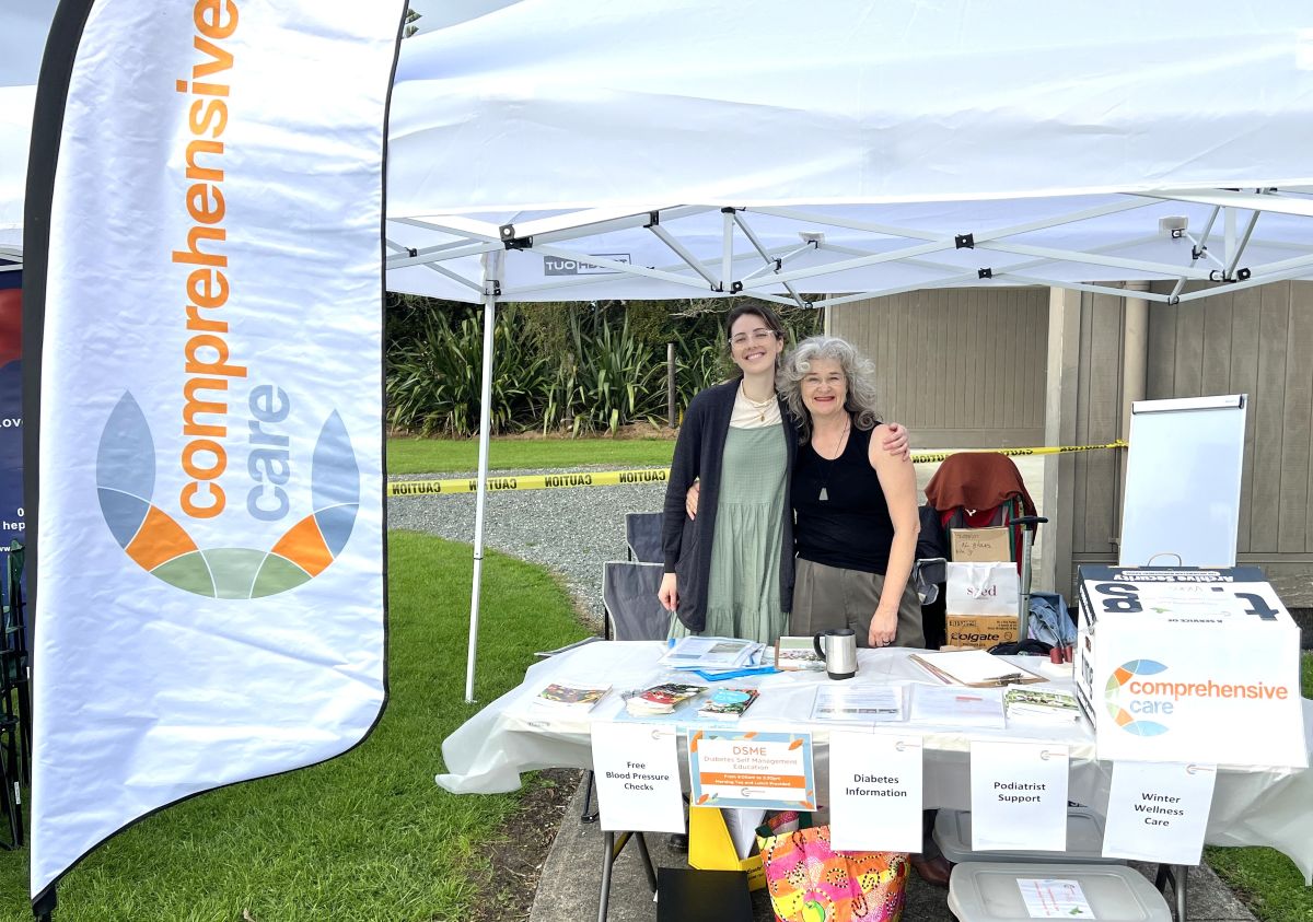 comprehensive-care-pho(resized) Comprehensive Care staff standing behind a branded stall at an event in Northland.