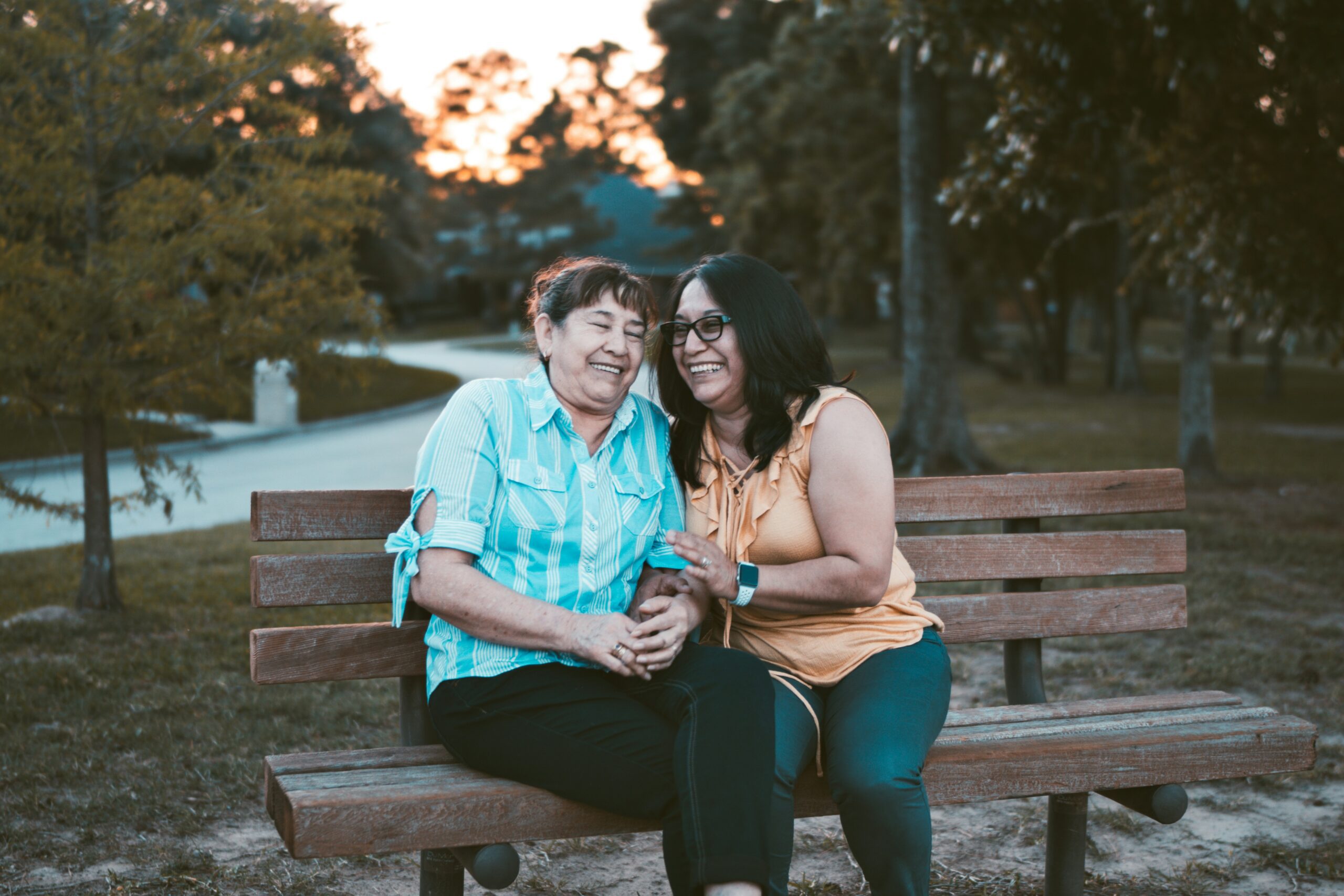 Two women sitting on a bench talking about diabetes self-management.