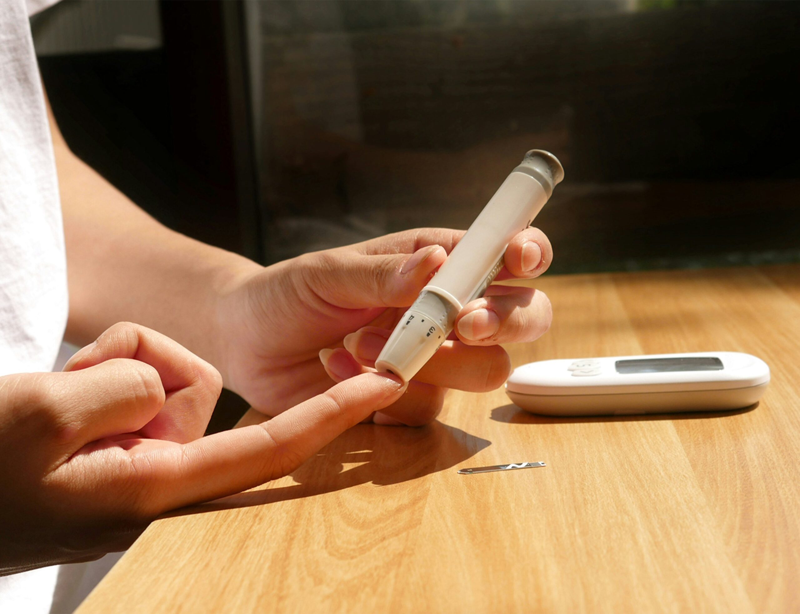 A person tests their glucose levels as part of diabetes self management practices